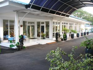 فندق سينجكارينج ترانسيت في تانغيرانغ: مبنى به الكثير من النوافذ والنباتات الفخارية