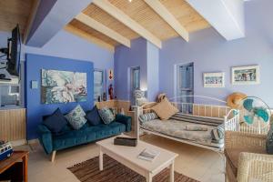 a living room with blue walls and a blue couch at Just Rest Holiday Home in Paternoster