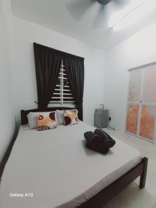 a bedroom with a large white bed with a window at Nova Stay SP in Sungai Petani