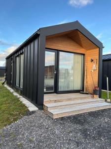 a house with a black roof and a wooden deck at Willa Rauha 2B, minikoti, wifi, ei saunaa in Lumijoki