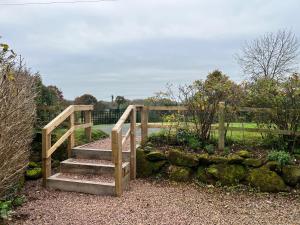 a wooden bridge with stairs and a fence at Stone Hill Farm B&B in Shrawley