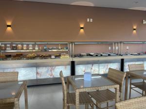 a restaurant with tables and chairs and a counter at Hotel Roni in Itabuna
