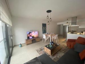a living room with a couch and a tv and a table at Blue Serenity - DeJa Blue 2 - C13 in Kalogrea