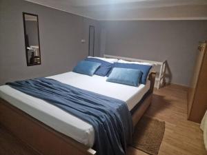 a bedroom with a large bed with blue pillows at Casa Rita-Superior Room in Giarre