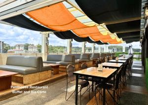 Un restaurante con mesas y sillas en la azotea. en Citylight Hotel, en Baguio