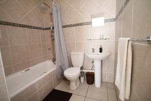 a bathroom with a toilet and a sink and a tub at Michael Point 6 in Shelly Beach +12 photos