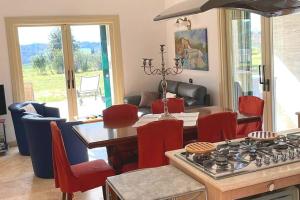 Il comprend une cuisine et un salon avec une table et une cuisinière. dans l'établissement Villa Terme Saturnia, à Saturnia