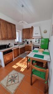 a kitchen with wooden cabinets and a table with chairs at Wildflowers House - JApartments in Genoa