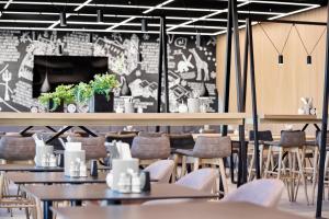 a restaurant with tables and chairs and a brick wall at H2 Hotel Saarbrücken, Trademark by Wyndham in Saarbrücken