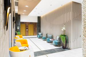 a waiting area with chairs and tables in a lobby at Three Corners Avenue Hotel in Budapest +63 photos