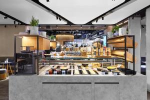 a restaurant kitchen with a lot of food on display at H2 Hotel Saarbrücken, Trademark by Wyndham in Saarbrücken