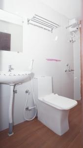 a white bathroom with a sink and a toilet at Hashtag Hive in Puducherry