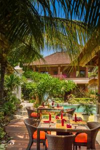 a patio with tables and chairs in front of a house at Rama Shinta Hotel Candidasa in Candidasa