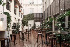 an empty restaurant with tables and stools in a building at Hospes Puerta de Alcalá, a Member of Design Hotels in Madrid