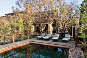a deck with chairs and a swimming pool at The Riverine Lodge in Welgevonden Game Reserve