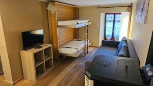 a living room with a couch and a tv and bunk beds at Casa Curnet in Balme