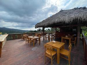 a restaurant with tables and chairs on a deck at Villa Bambu Rinjani & Restaurant in Senaru +35 photos