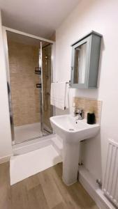 a white bathroom with a sink and a shower at Fabulous 2bedroom flat in Coventry +6 photos