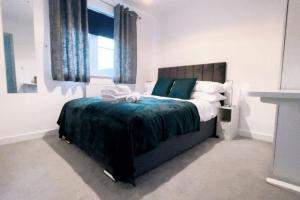a bedroom with a large bed with towels on it at Fabulous 2bedroom flat in Coventry