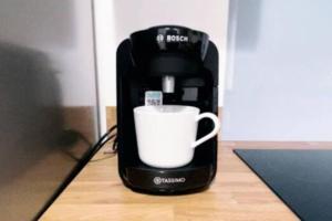 a coffee maker with a white cup on a table at Fabulous 2bedroom flat in Coventry