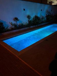 a swimming pool with blue water in a room at Flat aconchegante em Juquehy! Com piscina! in Praia de Juquehy