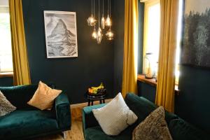 - un salon avec un canapé vert et une chaise dans l'établissement Chalet-Apartement in ehemaliger Hofraite, à Bruchköbel