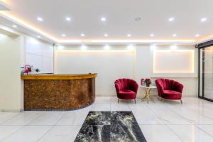 Un vestíbulo con dos sillas rojas y un bar. en Hotel Silviya, en Estambul