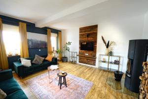 un salon avec un canapé et une télévision dans l'établissement Chalet-Apartement in ehemaliger Hofraite, à Bruchköbel