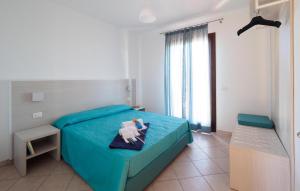 ein Schlafzimmer mit einem blauen Bett mit einem Handtuch darauf in der Unterkunft Nice Home In Marina Di Modica in Marina di Modica