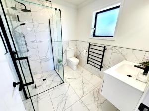 ein Badezimmer mit Dusche, Waschbecken und Toilette in der Unterkunft The Cozy Oasis in Napier + 14 Fotos