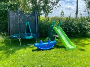 two childrens play equipment in the grass at Kustverhuur, Park Schoneveld Stern 218 in Breskens