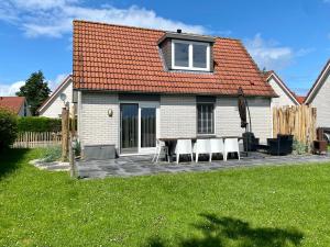 a house with chairs and a table in the yard at Kustverhuur, Park Schoneveld Stern 218 in Breskens