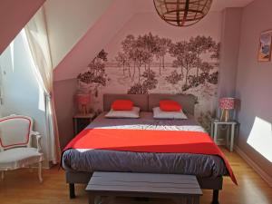 ein Schlafzimmer mit einem Bett mit roten Kissen darauf in der Unterkunft Plage du Pont - Chambres d'Hôtes in Saint-Malo