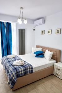 a bedroom with a large bed with blue pillows at Apartament Atlantis by ALZ in Mamaia Nord