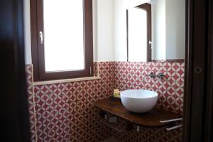 a bathroom with a bowl sink on a wooden table at Casale Spina in Santa Caterina Villarmosa