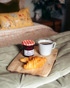 a tray of croissants and a cup of coffee on a bed at 4 - Walkers Cottage - Scandinavian BBQ hut -Open fire in Pont Sticill