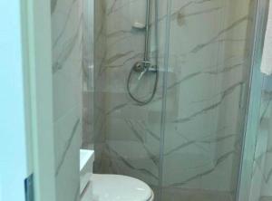 a shower with a glass door next to a toilet at Charming Sinj Town Studio Apartments in Sinj