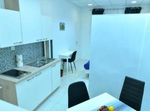 a kitchen with white cabinets and a table and chairs at Charming Sinj Town Studio Apartments in Sinj