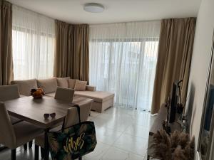 a living room with a couch and a table with a laptop at Apartament with LOVE in Bahçeli