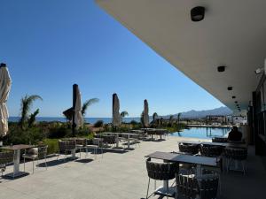 a patio with tables and chairs next to a pool at Apartament with LOVE in Bahçeli