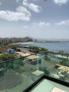 a glass balcony with a view of the water at Apartamento Deluxe Santa Filomena in Mindelo