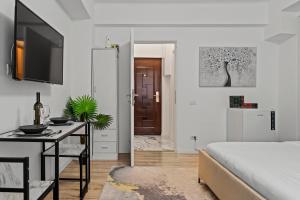 a bedroom with a bed and a desk and a tv at Garsoniera LUX Piata Natiunile Unite in Bucharest