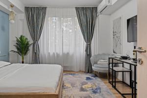 a bedroom with a bed and a table and a chair at Garsoniera LUX Piata Natiunile Unite in Bucharest