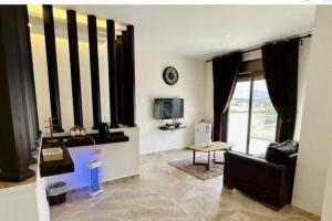 a living room with a couch and a tv at Private Pool - Relax Chalet Deadsea in Amman