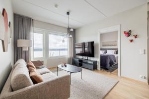 a living room with a couch and a tv and a bed at Penthouse Valsa in Rovaniemi