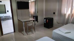 a room with a table and a bar in it at Hotel Globo in Cianorte