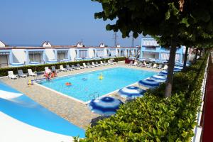a swimming pool with chairs and people in a hotel at Residence Soleluna in Praia a Mare