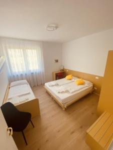 a room with two beds and a chair in it at Countryhouse Verso in Rovereto