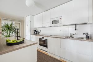 - une cuisine blanche avec un bol de fruits sur un comptoir dans l'établissement Penthouse Valsa, à Rovaniemi