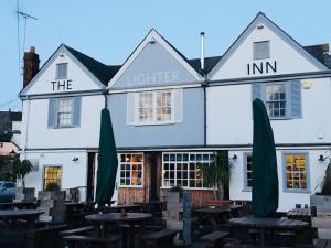 a white building with tables and umbrellas in front of it at Stunning Town house with parking, fire, games room in Topsham